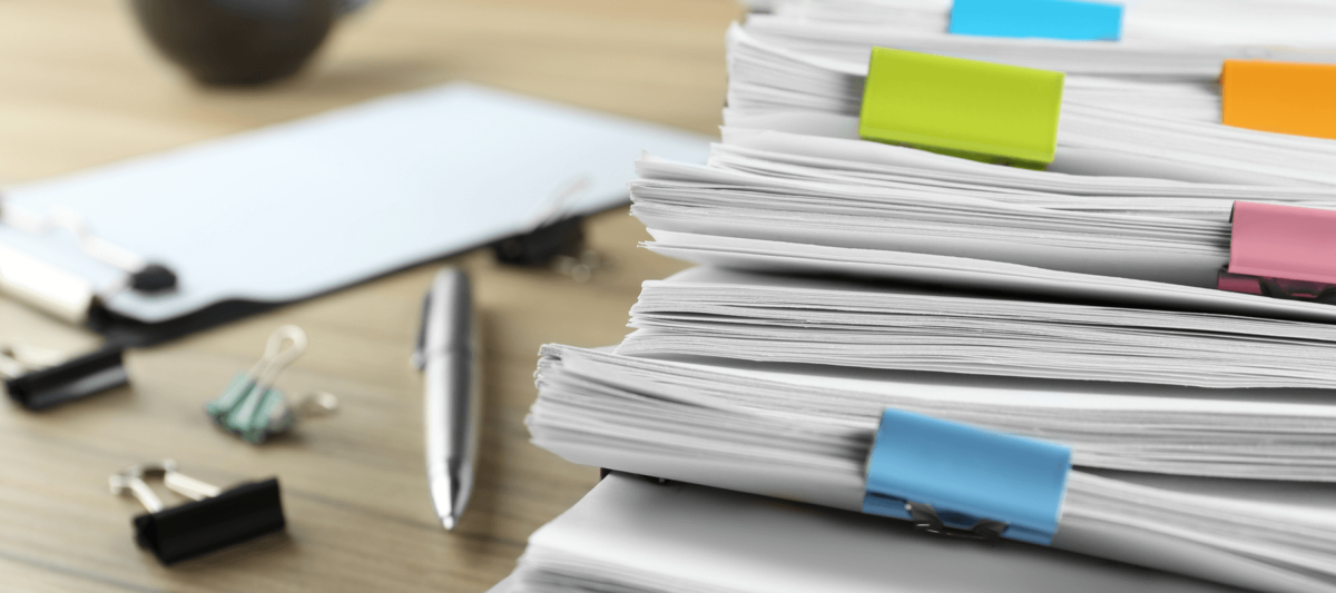 A pile of documents on a desk. 